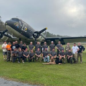 A group of people standing in front of an airplane.