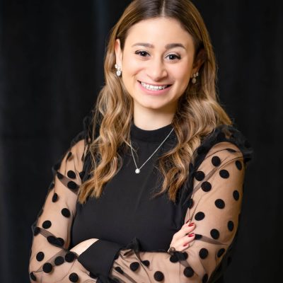 A woman in black shirt and polka dot dress.